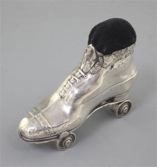 An Edwardian novelty silver roller skate pin cushion on rotating wheels, by Crisford and Norris, Birmingham 7cm.